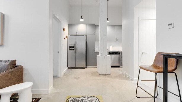 A modern kitchen with stainless steel appliances, a white countertop, and pendant lighting. - Downtown Living in Richmond's Amazing Shockoe Bottom (Richmond)