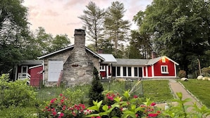 A stone chimney, a red barn, and a red house with a porch. - Waterfront Home at the  River Haven Sanctuary (Richmond)