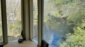 A room with large windows overlooking a river and forest. - Waterfront Home at the  River Haven Sanctuary (Richmond)