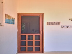 Una puerta de madera con un panel de vidrio y diseño de cuadrícula.