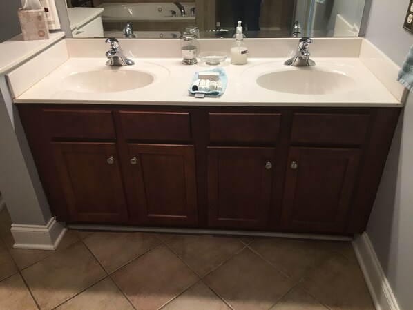 A bathroom with two sinks, a mirror, and a towel rack.
