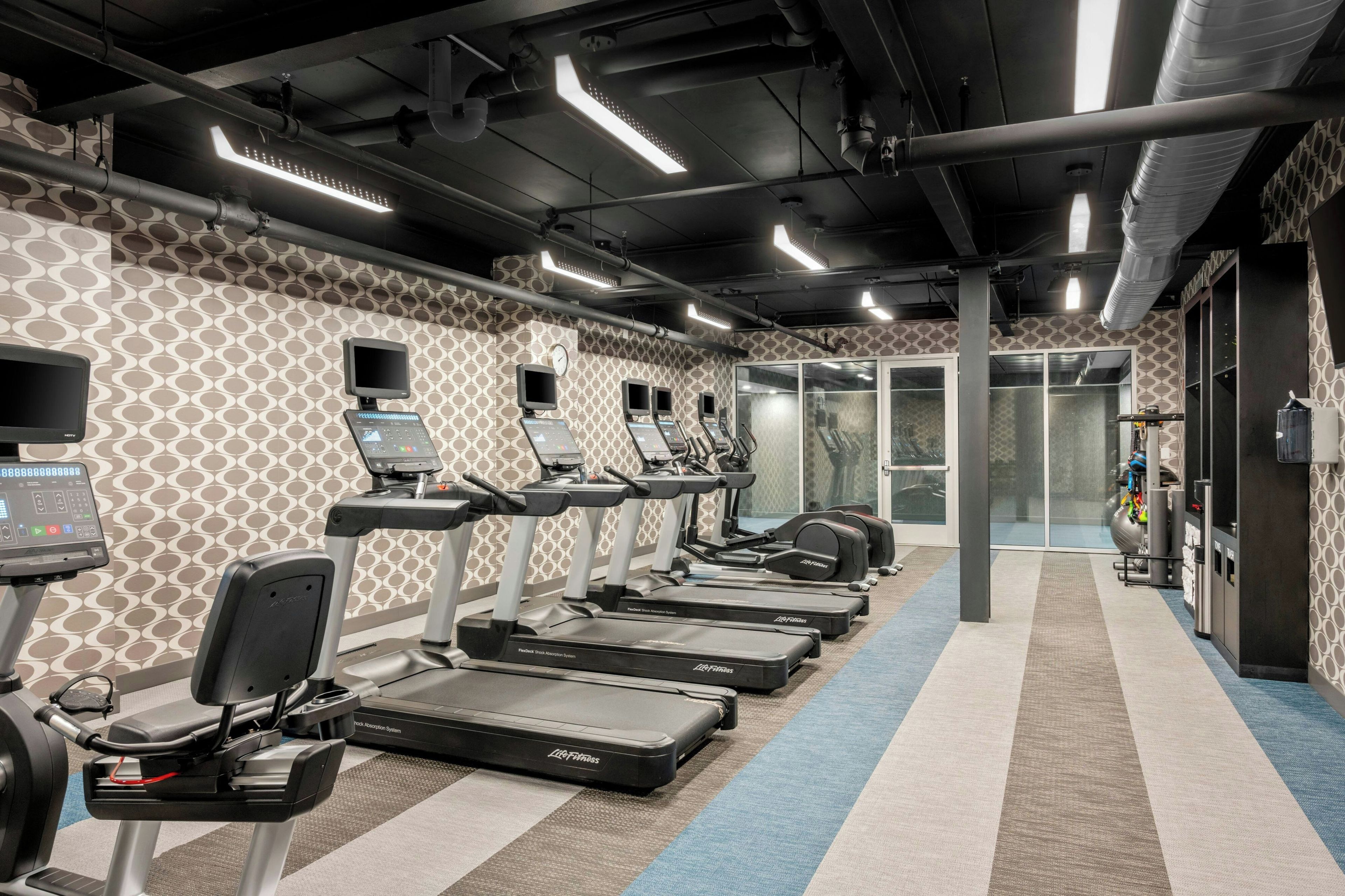 A gym with treadmills, exercise bikes, and weight machines.