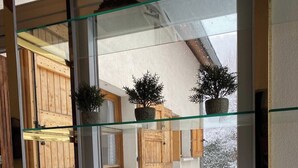 A glass display case with a chessboard and potted plants, set against a backdrop of wooden shutters and a snowy landscape. - SUPERB HOUSE, GREAT LOCATION - SLEEPS 10 (Allemont)