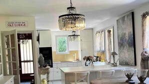 A spacious kitchen with a central island, a chandelier, and a sign indicating a ski lodge. - SUPERB HOUSE, GREAT LOCATION - SLEEPS 10 (Allemont)