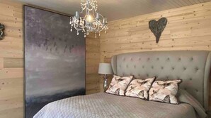 A bedroom with a large bed, a chandelier, a heart-shaped decoration on the wall, and a painting. - SUPERB HOUSE, GREAT LOCATION - SLEEPS 10 (Allemont)