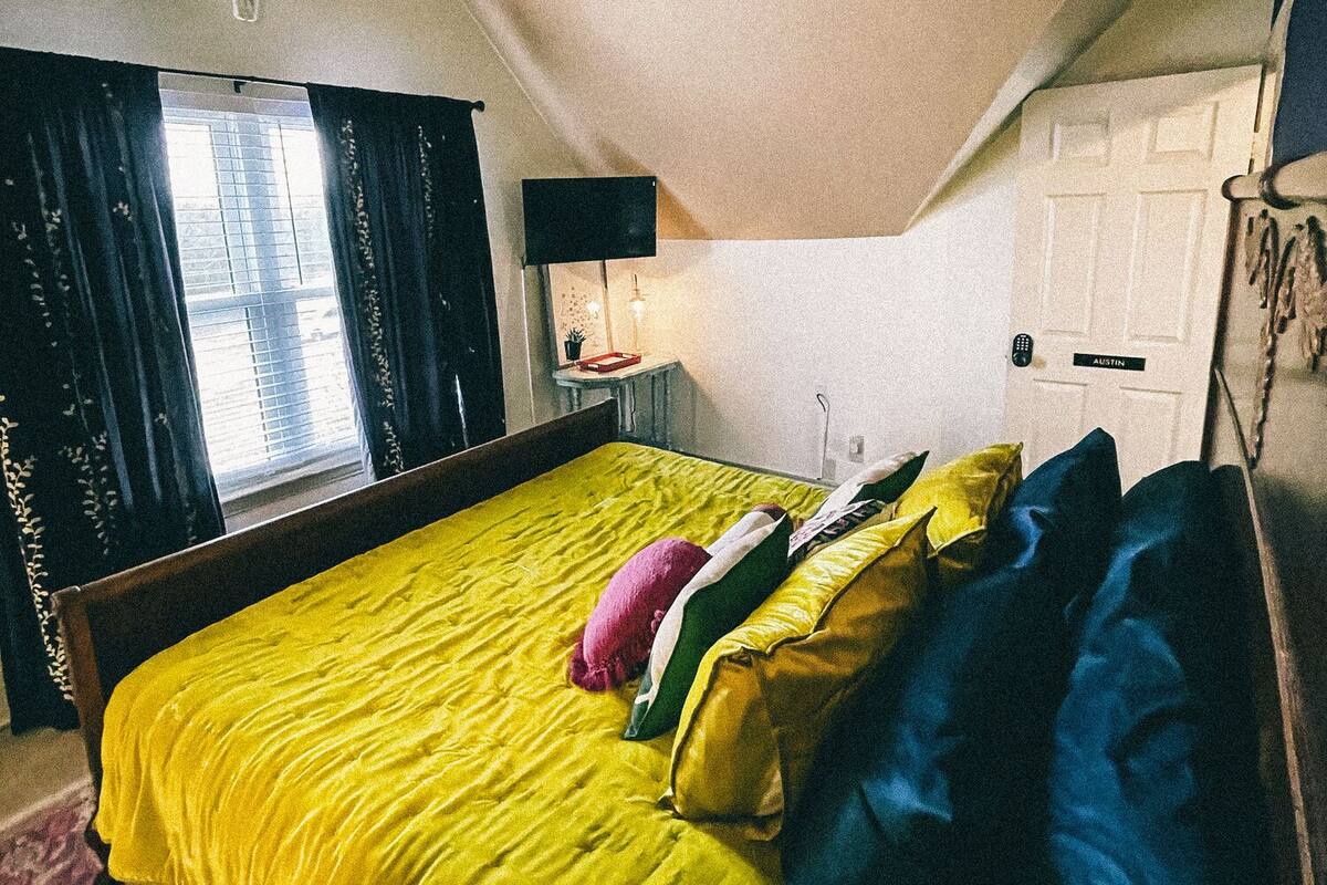 Ein Zimmer mit einem Bett, einer Lampe, einem Fenster und einer Tür.