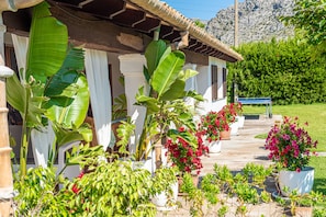 A house with a porch, large plants, and potted flowers. - Impressive villa within walking distance to Pollensa (Pollensa / Pollen ça)