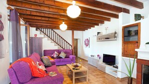 A living room with a purple sofa, wooden coffee table, and a fireplace.