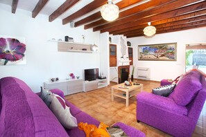 Un salon avec une cheminée, un téléviseur et un canapé.