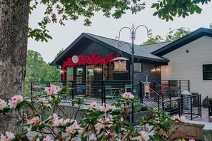A building with a modern design, featuring a balcony with seating and a staircase leading to an upper level. - 2BR + 2BA Lake Chatuge Cabin w/ Mountain Views! (Hiawassee)