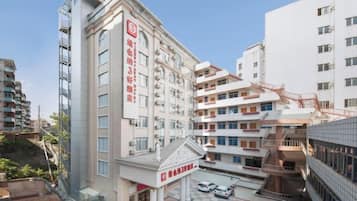 Un hotel de varios pisos con una entrada destacada, zona cubierta y varios espacios de estacionamiento.