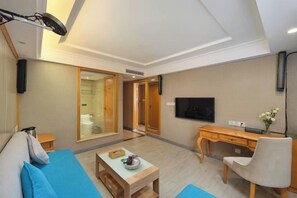 A modern living room with a sofa, a coffee table, a TV, and a desk. - Vienna 3 Best Hotel (Yangchun Bus Station) (Yangchun)