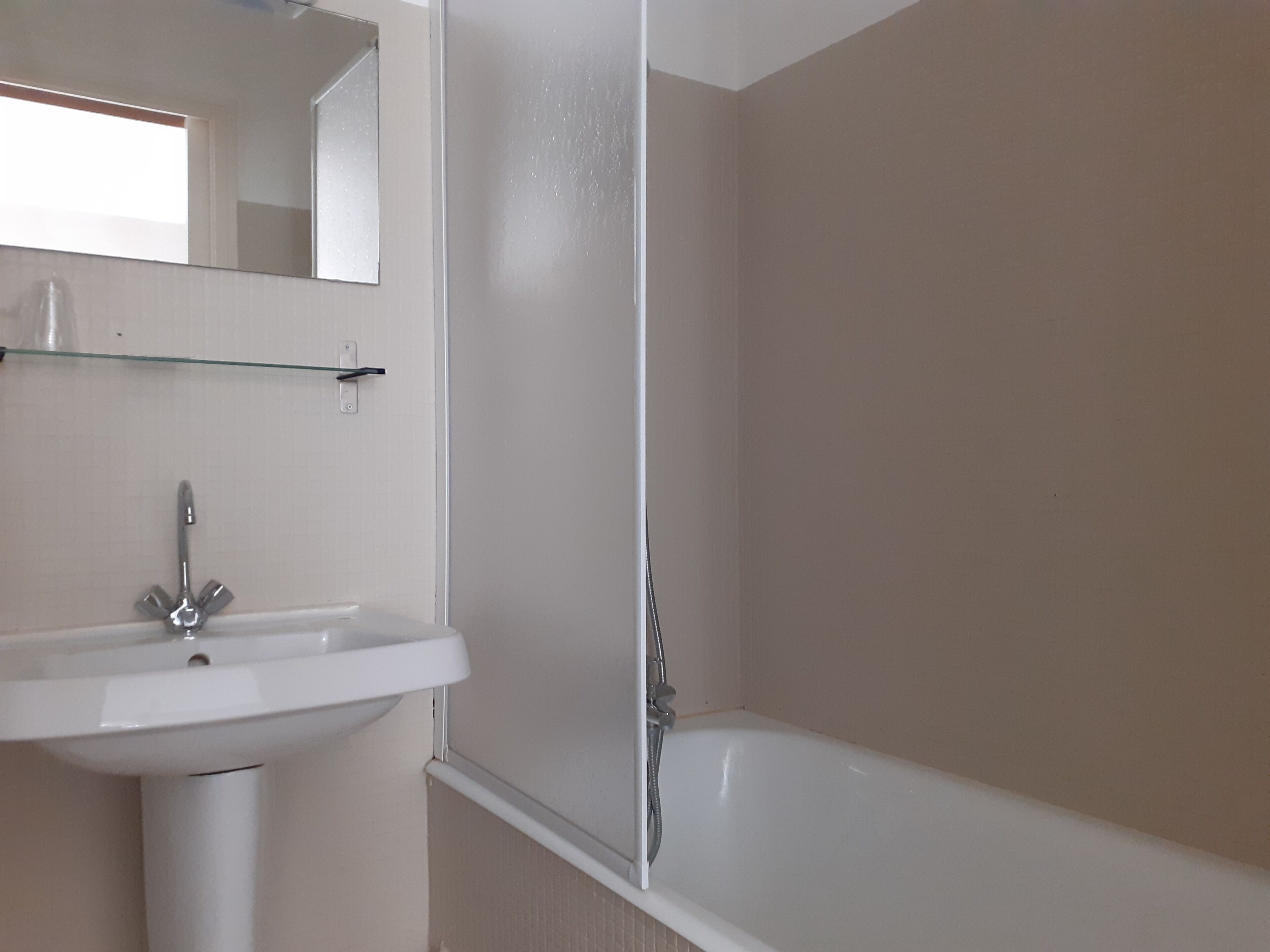 A bathroom with a white sink, a mirror, and a bathtub.