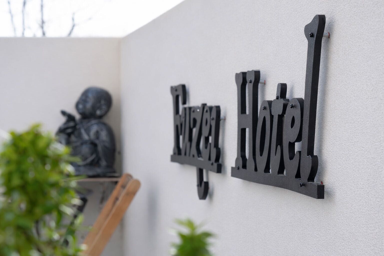 A metal sign with the words 'Hotel' mounted on a wall.