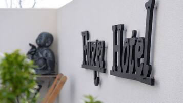 A metal sign with the words 'Hotel' mounted on a wall.