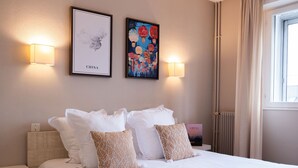 Ein Hotelzimmer mit einem Bett, zwei Wandlampen, einer gerahmten Karte und einem gerahmten Gemälde.