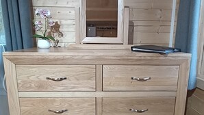 Un aparador de madera con seis cajones y un espejo encima.