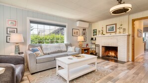 A living room with a fireplace, a sofa, a coffee table, and a rug.