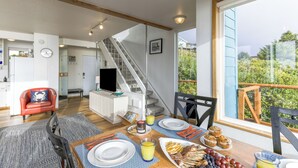 Una cocina moderna con comedor, una escalera y un balcón con vistas.