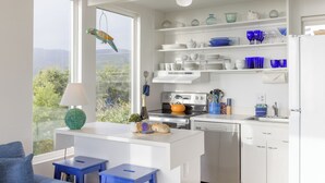 Una cocina moderna con armarios blancos, horno empotrado y vistas al exterior.