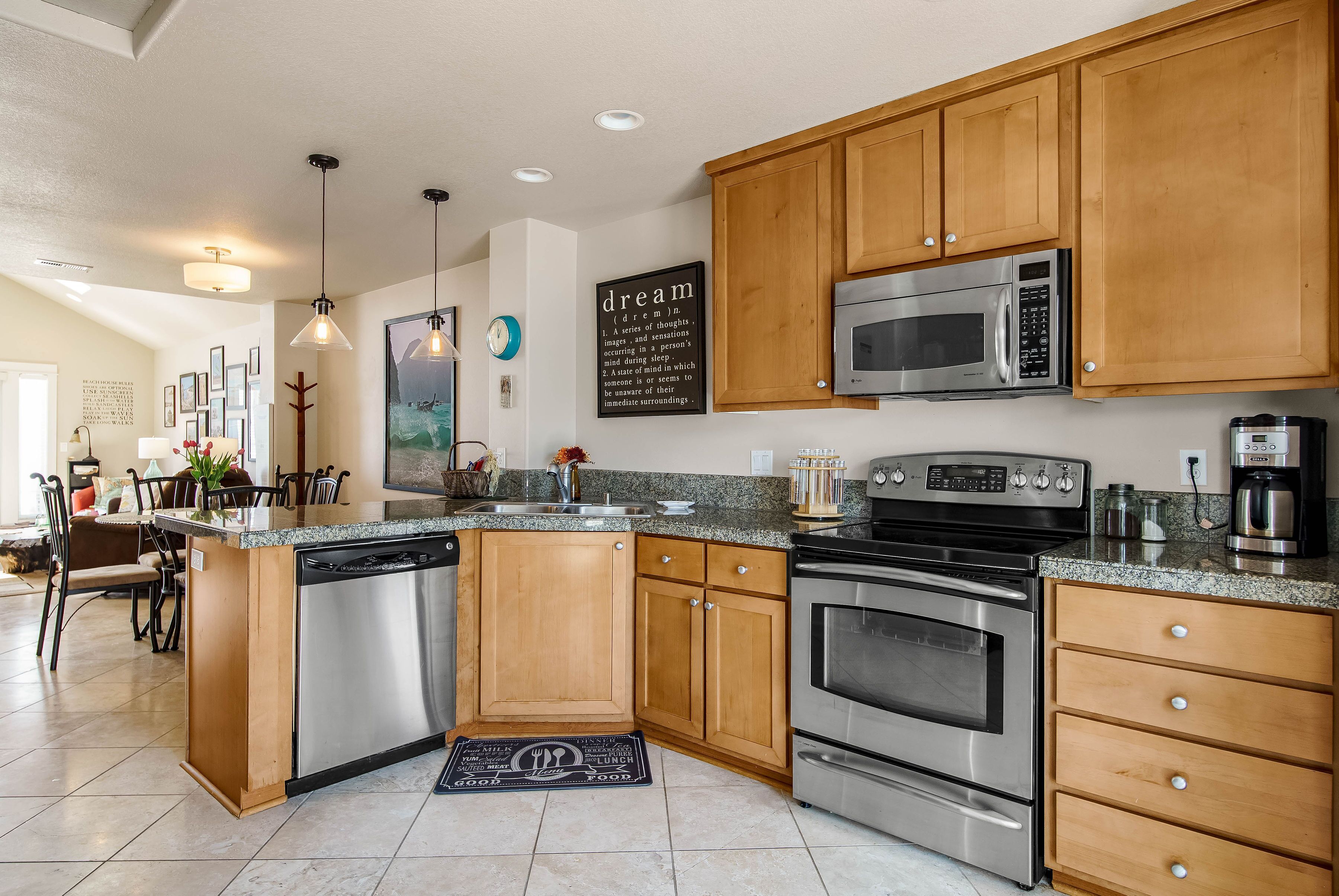 A modern kitchen with wooden cabinets, stainless steel appliances, and a granite countertop.