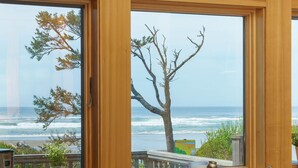 Una cocina con vista al océano, una botella de vino y dos copas sobre una bandeja de madera.