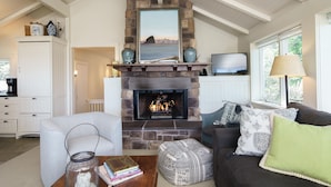 Una sala de estar con chimenea de piedra, televisor y un espacio de descanso acogedor.