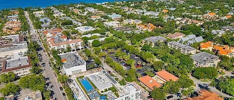 An aerial view of a residential area with a large building featuring a swimming pool and multiple stories.