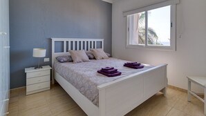A bedroom with a bed, nightstand, and window.