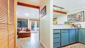 Eine moderne Küche mit blauen Schränken, einer Holz Arbeitsplatte und einem großen Fenster.