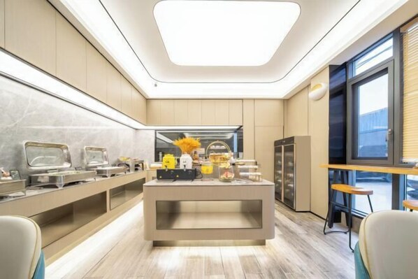 A modern hotel room with a central buffet area, a large window, and a seating area with a view. - Ruidu Hotel Wenzhou Wutian (Wenzhou)