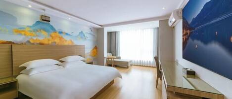 A modern hotel room with a large bed, a desk, and a wall-mounted TV.