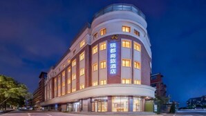 Un hôtel doté d’une façade incurvée, de nombreuses fenêtres et d’une enseigne lumineuse.