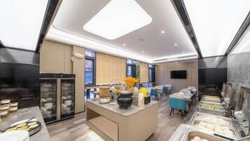 A modern kitchen with a central island, built-in appliances, and a dining area with blue chairs.