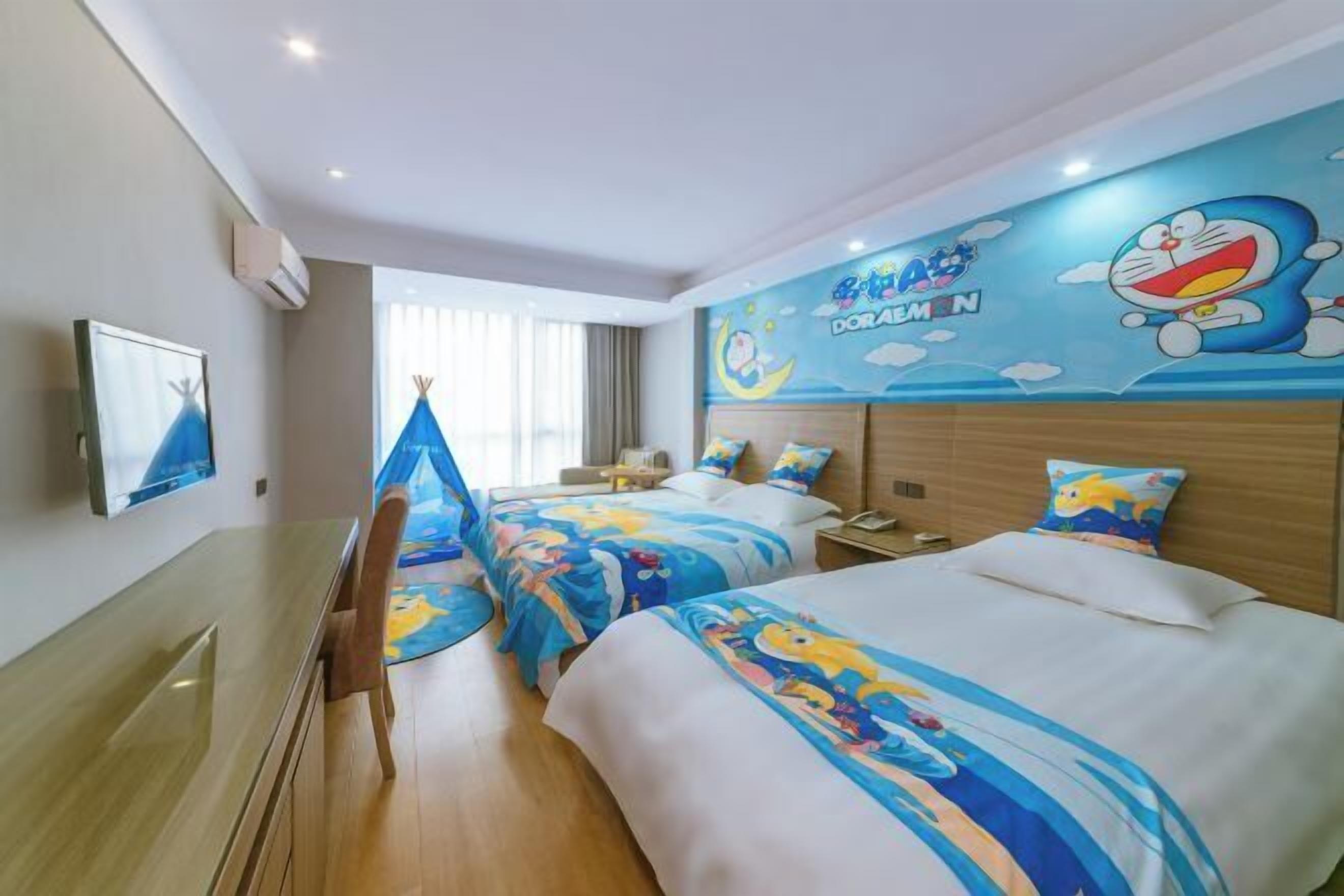 Habitación de hotel con dos camas, un escritorio y una silla. En la pared, un mural grande con un personaje de caricatura.