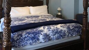 A four-poster bed with a floral bedspread, a chandelier, and wall sconces. - Pendleton House Historic Inn and B&B (Pendleton)