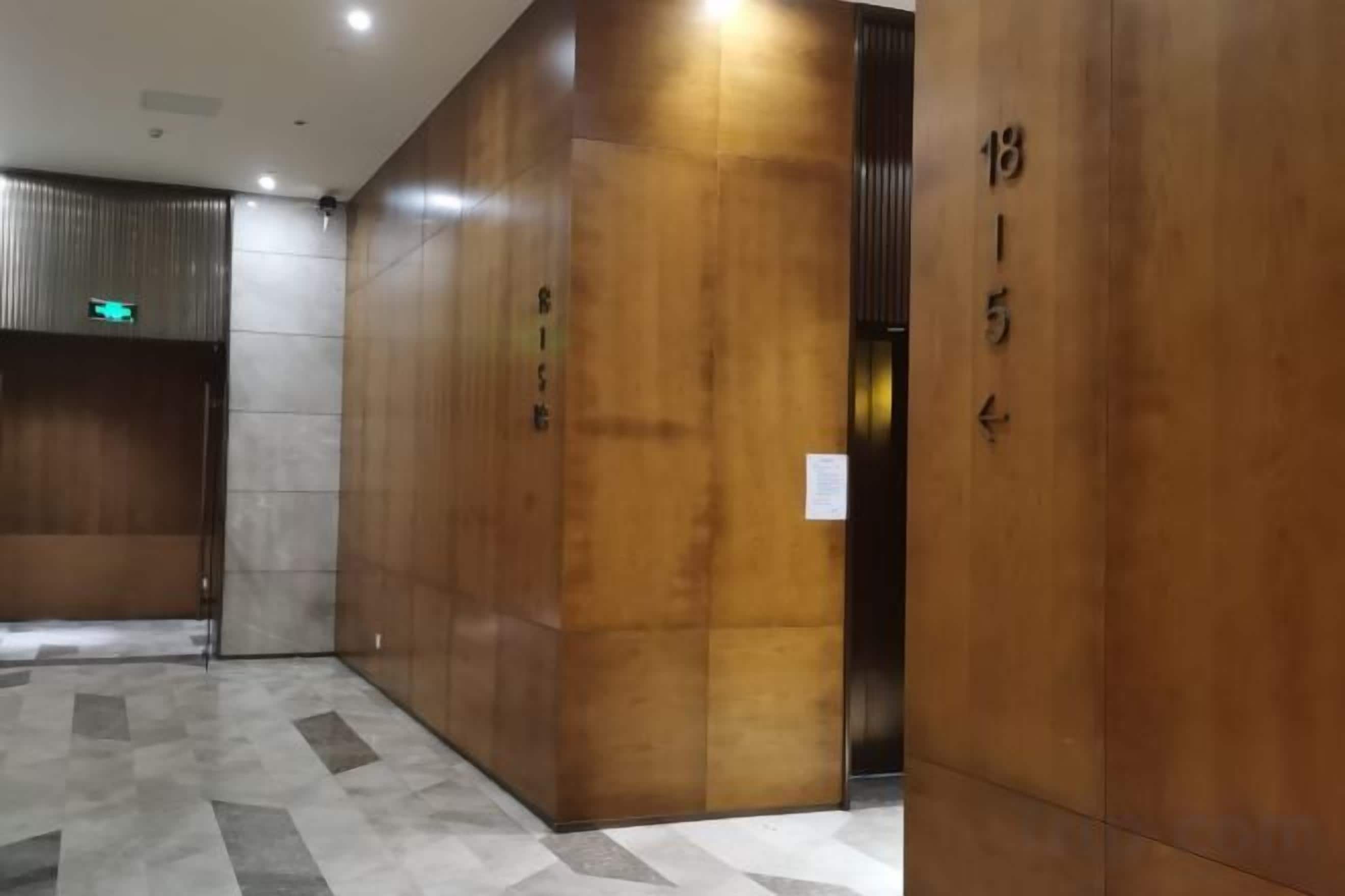A hallway with a wooden wall and a tiled floor.