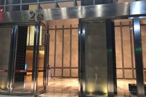 A hotel entrance with a metallic door, a visible number '2', and a tiled floor. - Kaluowei Apartment (Zheshang Building) (Dongguan)