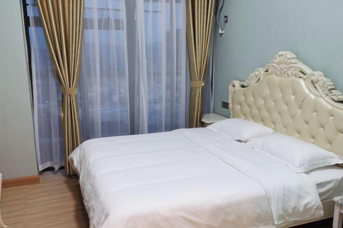 A bed with a tufted headboard, a white bedspread, and two pillows.