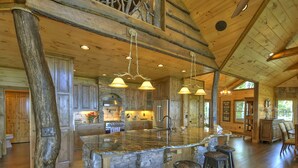 A spacious kitchen with a large island, wooden ceiling beams, and pendant lighting. - The VUE Over Blue Ridge - Blue Ridge (Blue Ridge)