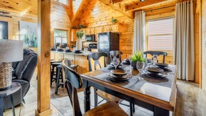 L'intérieur d'une cabane en bois comprend un coin repas, une cuisine et un espace de vie.