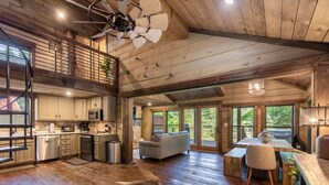 A spacious cabin with a high ceiling, wooden floors, a dining area, and a kitchen. - A Little Stoney River - Cartecay River in Ellijay (Ellijay)
