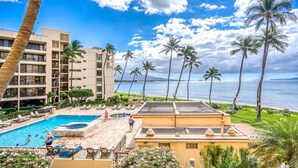 Un resort con piscina, palmeras y vista al océano.