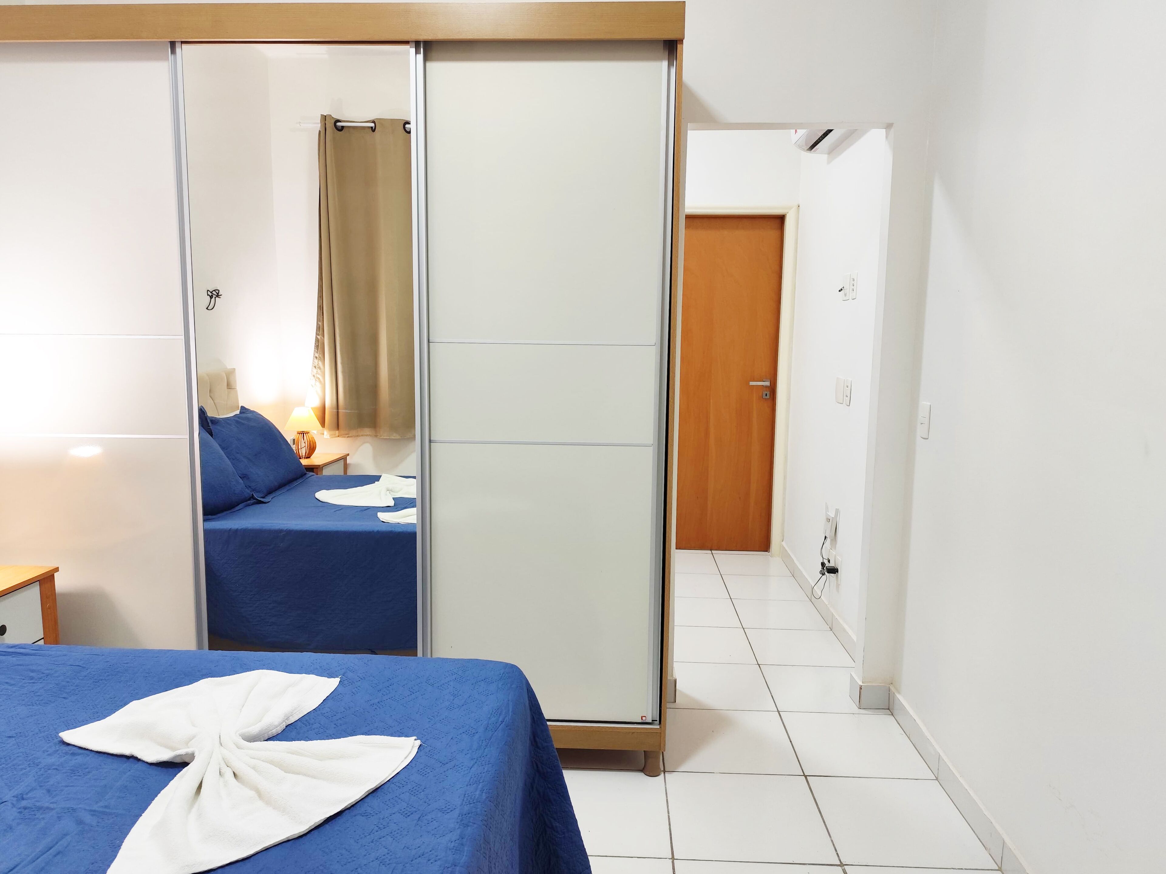 Une chambre d’hôtel avec un lit, une armoire, une salle de bain et une porte.