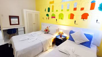 A hotel room with two beds, a desk, and a wardrobe.