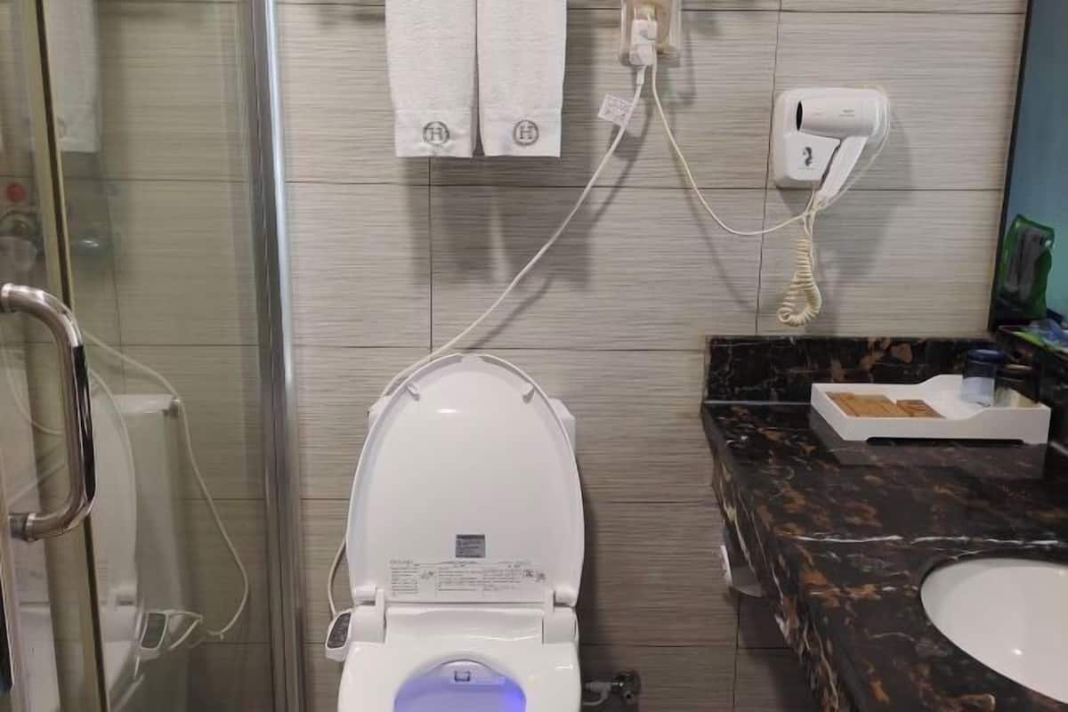 Bathroom features a glass shower enclosure, toilet with control panel, and a marble countertop with sink.