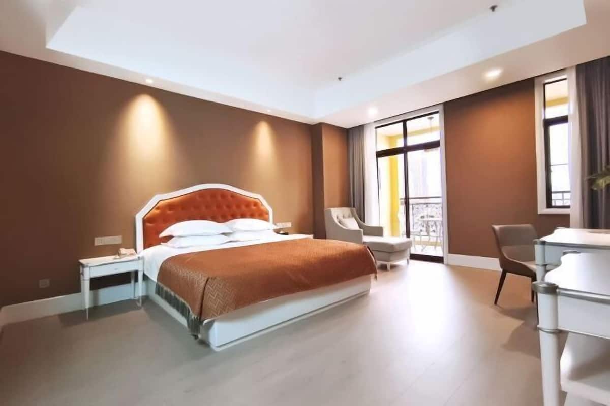 Una habitación de hotel moderna con una cama grande, un escritorio y una silla.