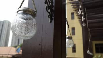 A glass bottle lantern hanging from a wooden post.