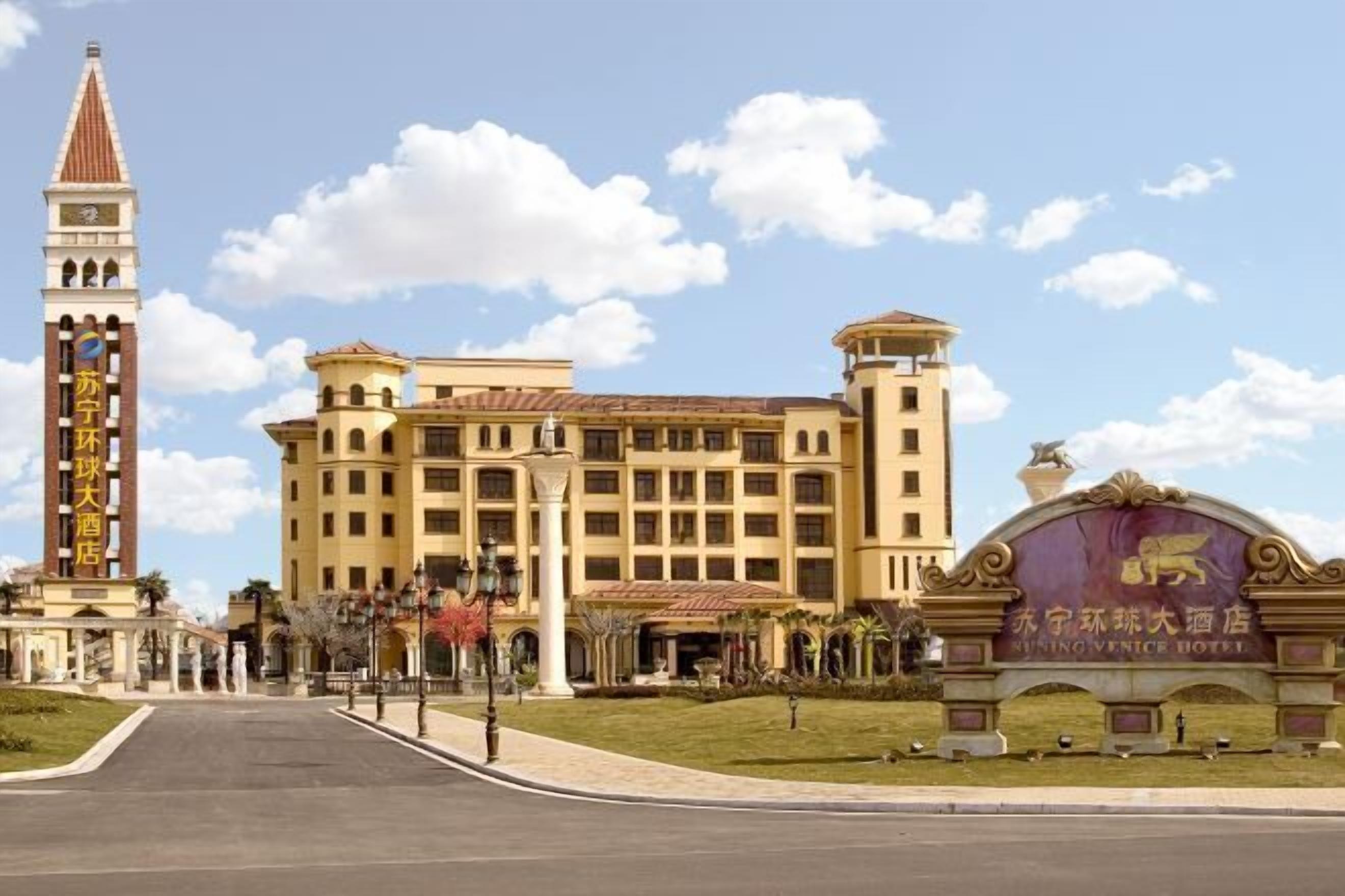 A hotel with a prominent clock tower and a large entrance gate.