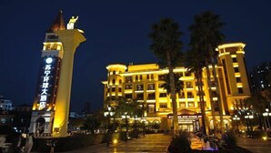 Ein Hotel mit einem markanten Glockenturm und einer gut beleuchteten Fassade.